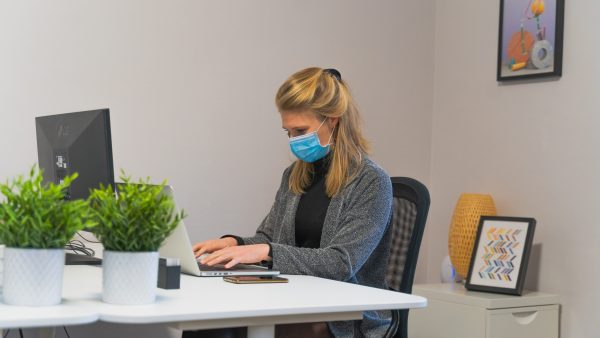 Masked lady working on laptop