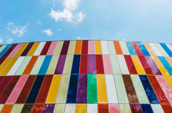 a multi-colored wall against the blue sky