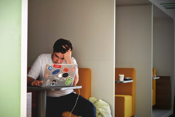 A frustrated student working on a laptop