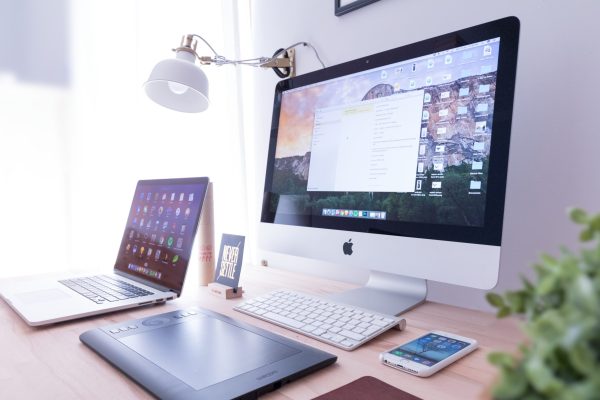 Various computer, laptop, tablet, and more on a table.