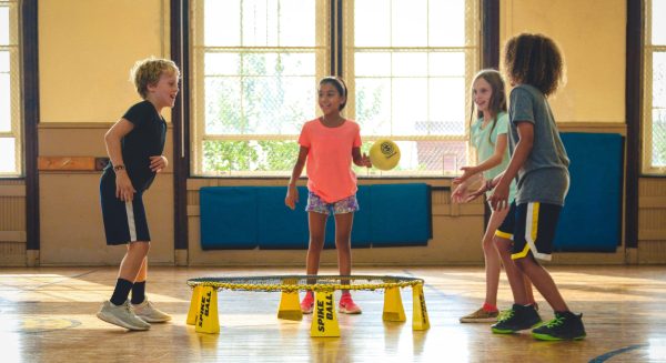 Three kids playing with a ball and bouncer