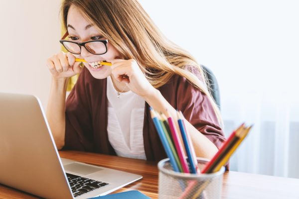 Lady biting pencil in frustration