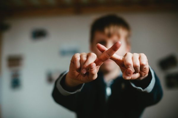 Student making X with fingers